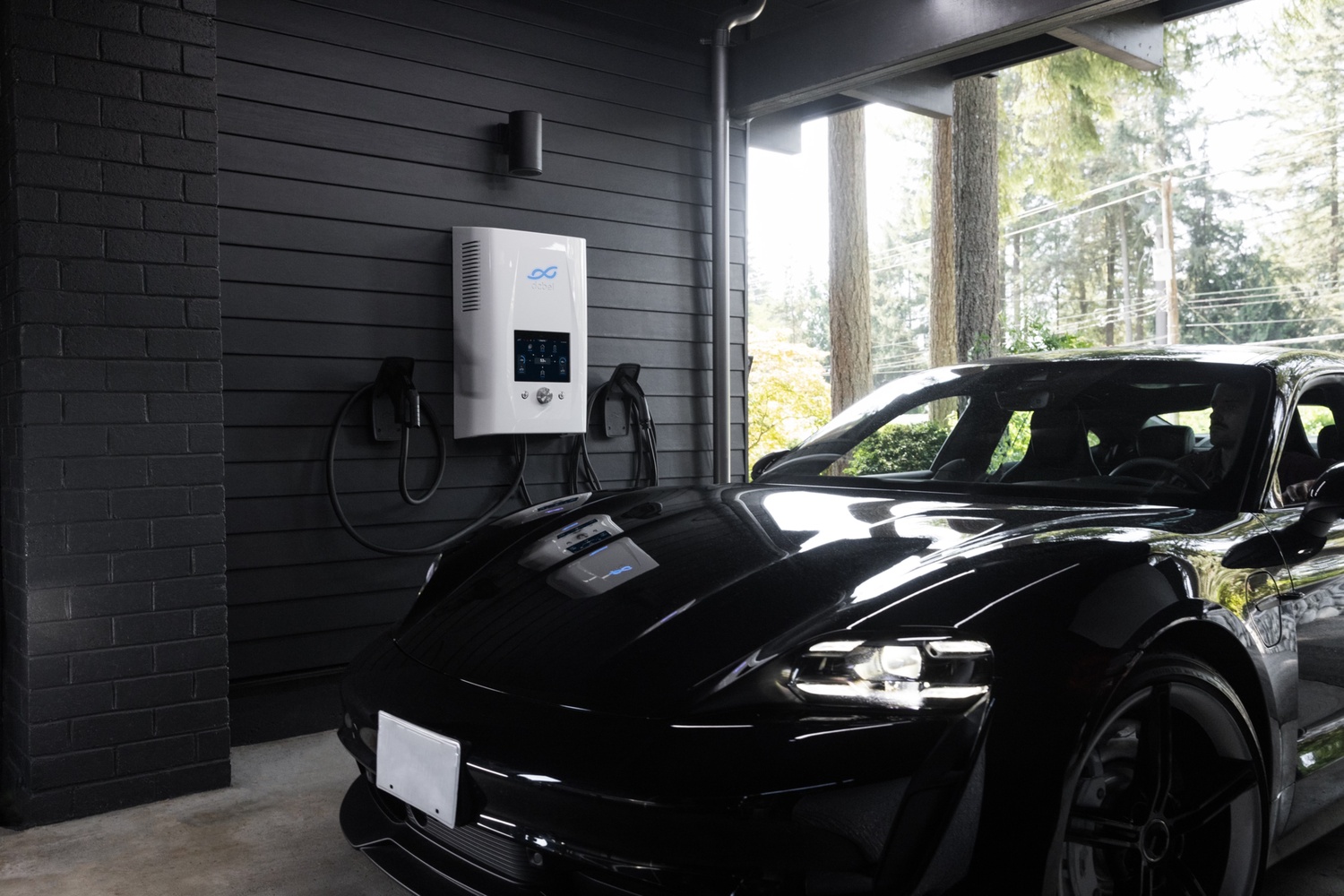 A black electric vehicle in a modern garage connected to a bidirectional charging station, illustrating Vehicle-to-Grid (V2G), green charging, and smart EV charging systems as part of an intelligent energy management system.