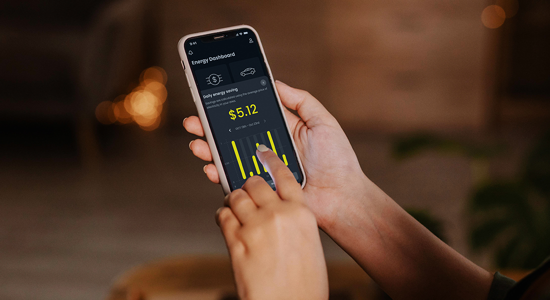 Person using a smartphone to monitor energy usage on an energy dashboard app